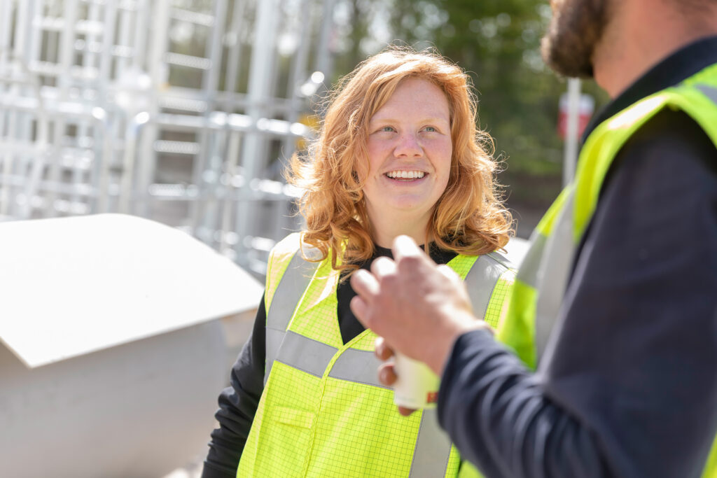 Supervisor Britt van Gpi Tanks XL in overleg met een collega op een tankbouwlocatie.